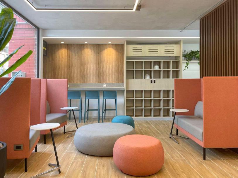 Sala de capacitaciones de Molymetnos en San Bernardo con zona de estar, puffs y repisas de madera