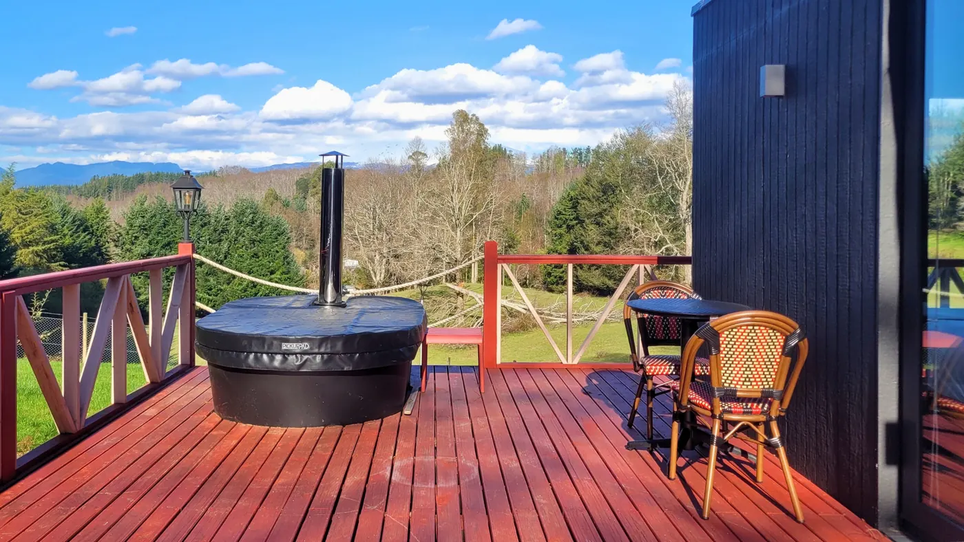 Tinaja caliente sobre el deck de una tiny house con vista a la cordillera