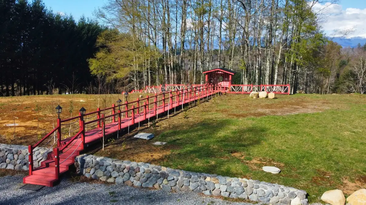 Nueva pasarela de madera roja sobre el terreno de la etapa 2