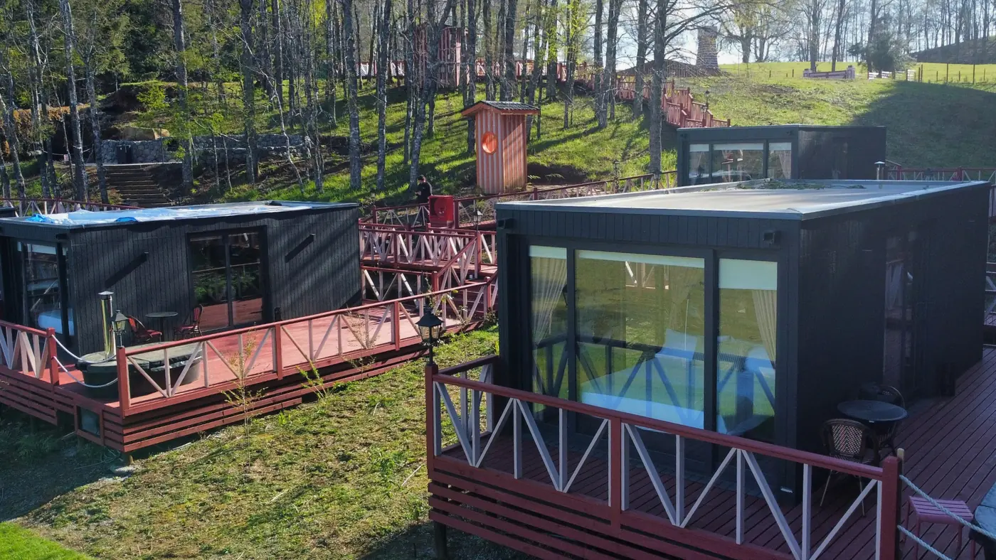Tiny house con ventanal de piso a cielo y deck perimetral