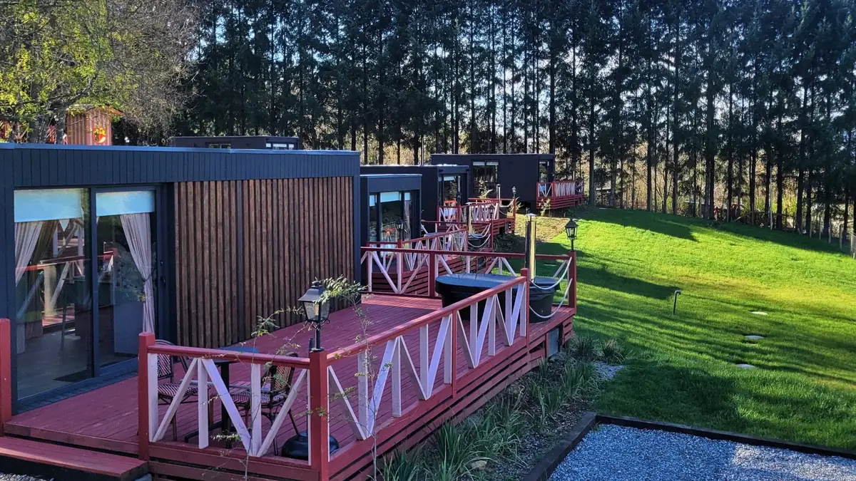 Tiny houses con terrazas de madera frente a la pradera
