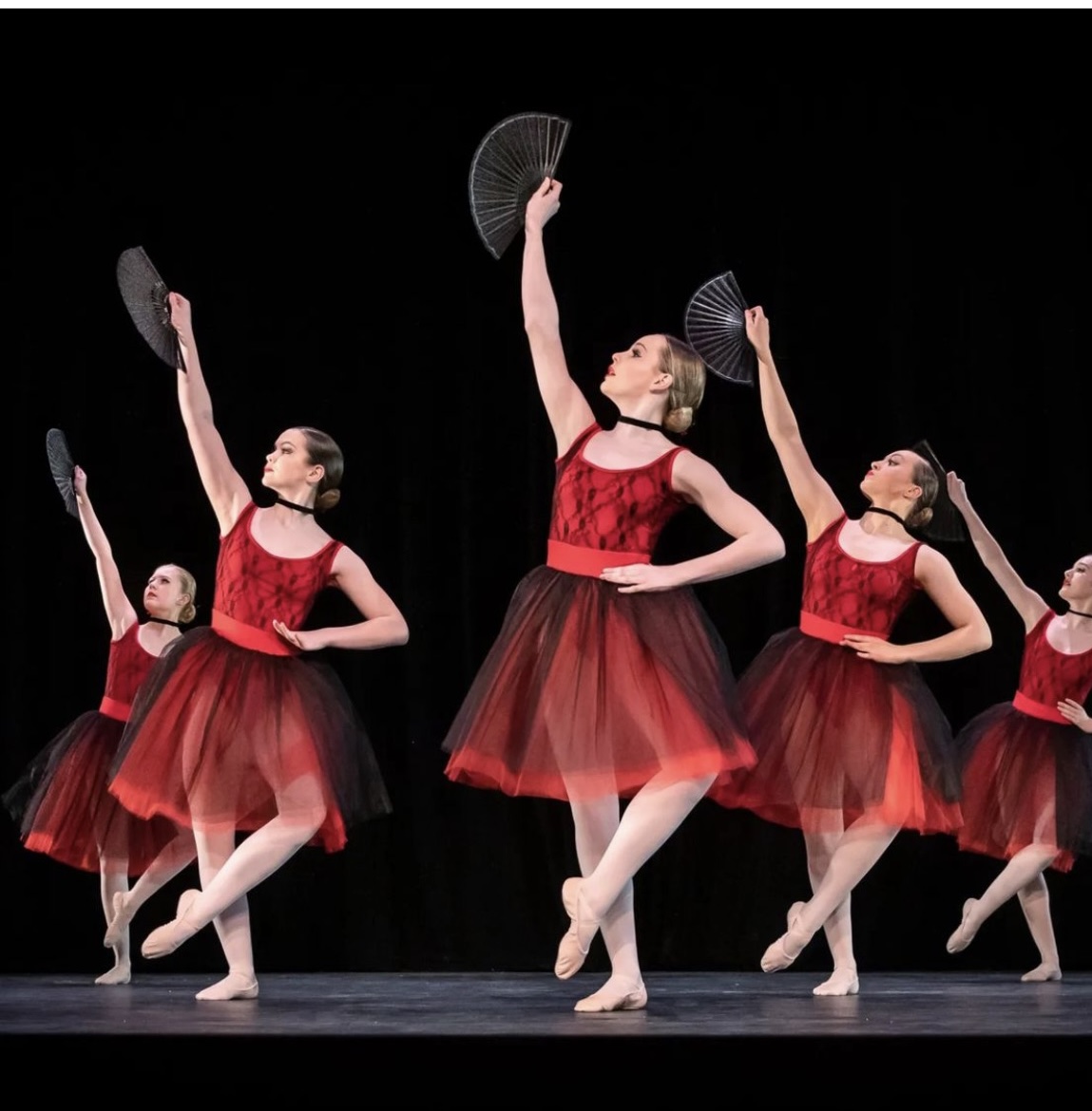 Ballet dancers with fans performing on stage