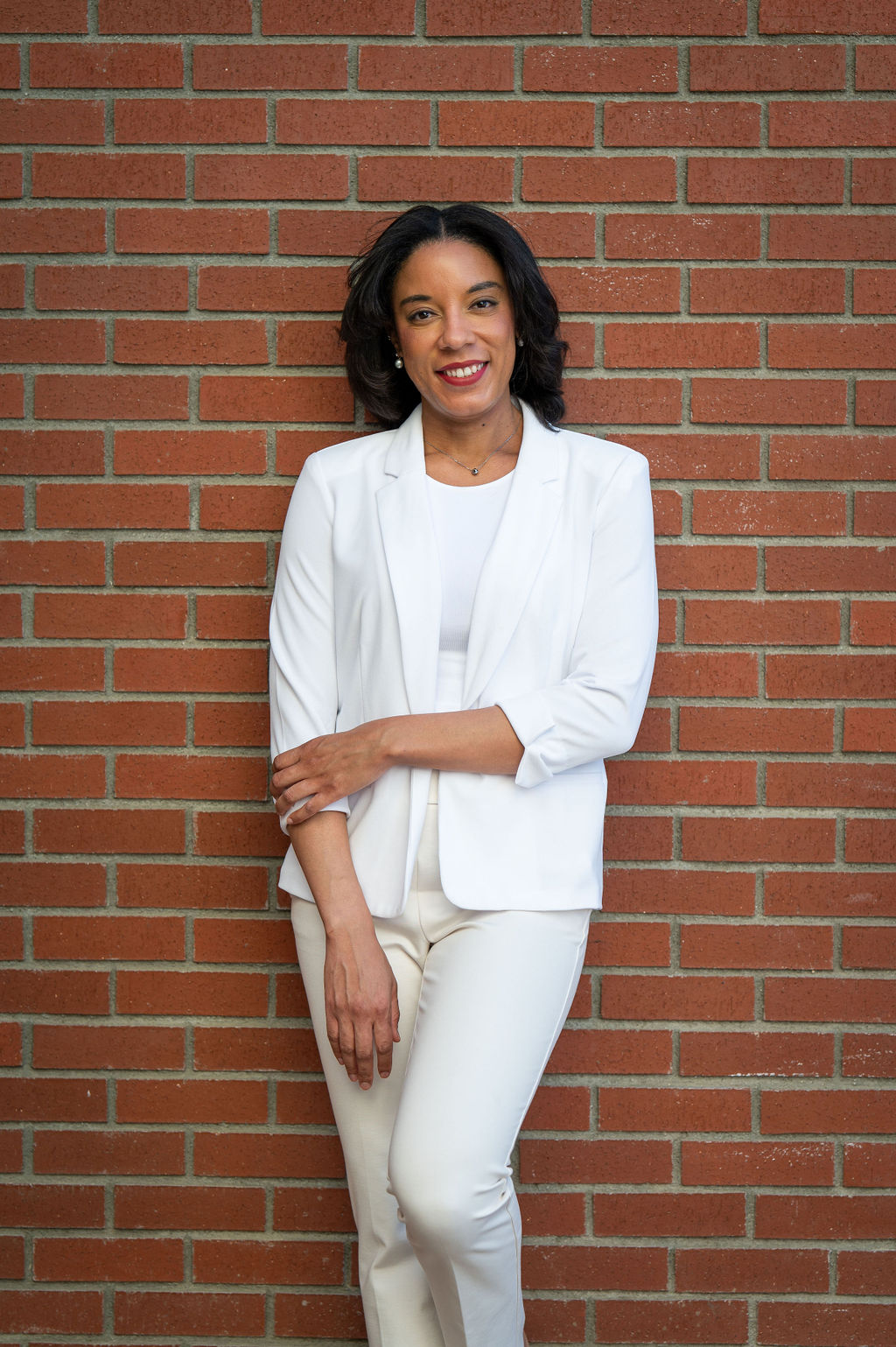 A woman standing against a brick wall