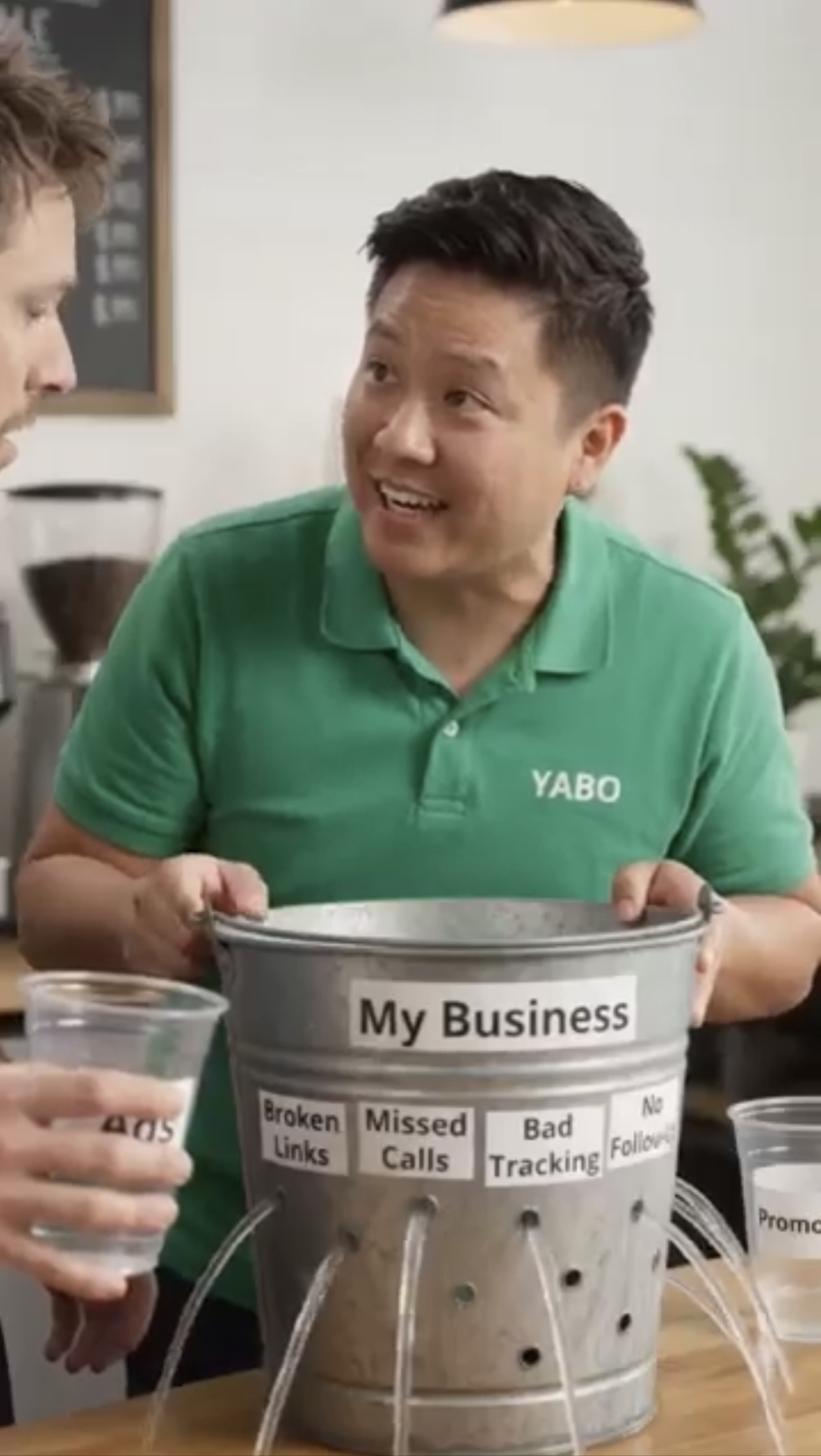 Man in a YABO shirt holding a leaking bucket labeled My Business