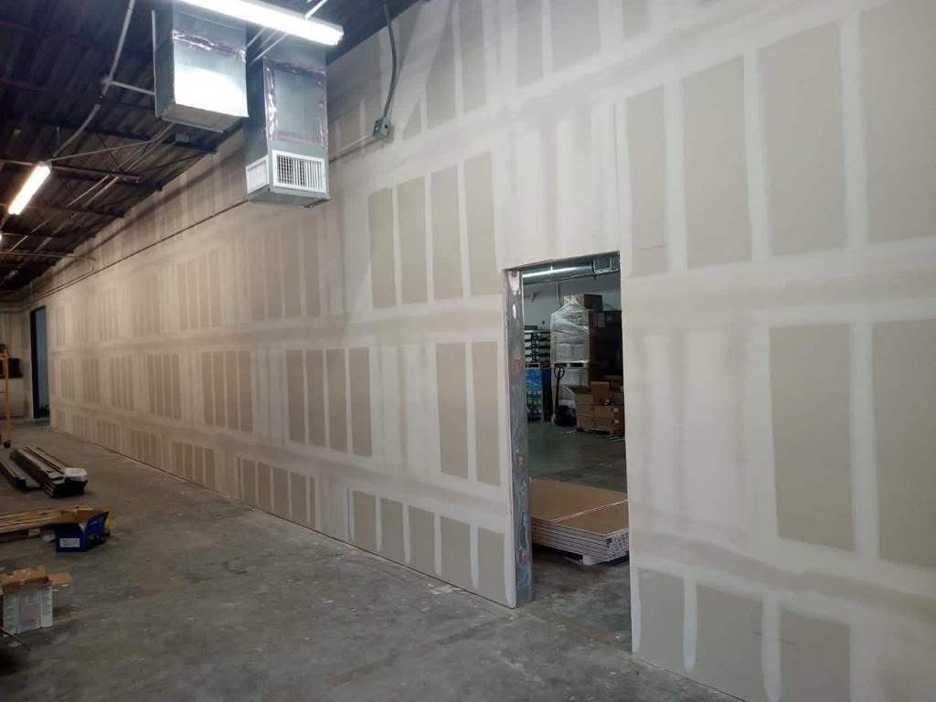 A drywall professional meticulously taping a seam on a new wall