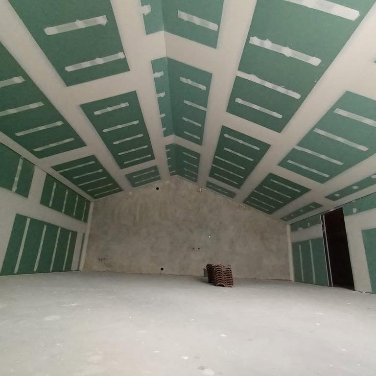 A craftsman repairing a damaged section of drywall with precision