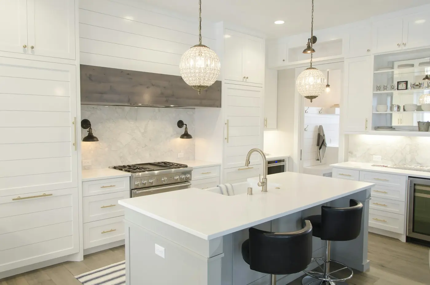 A pale, minimal kitchen with stone counters and concealed cabinetry.