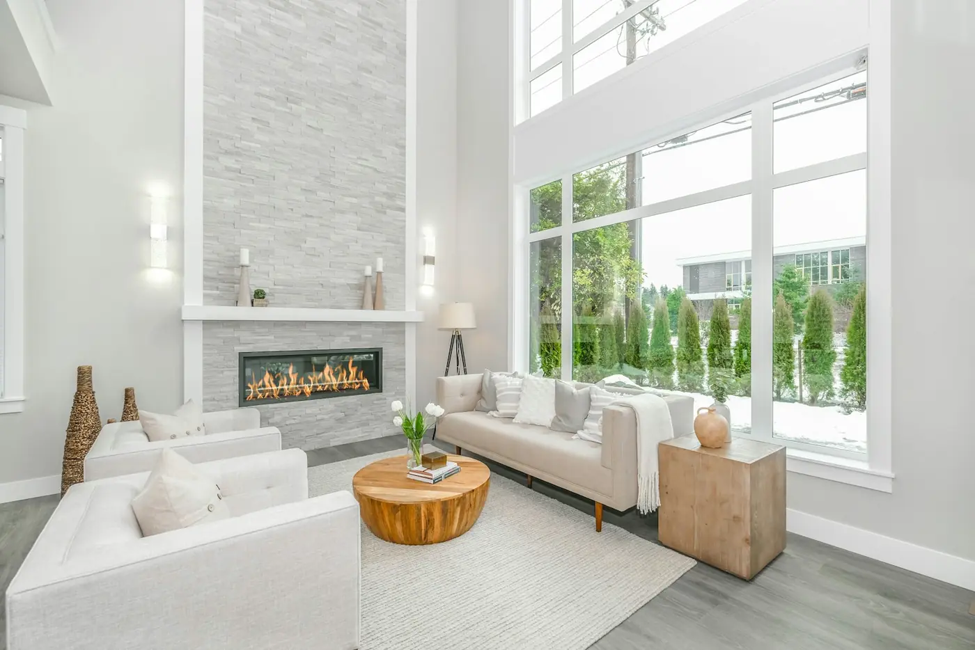 A pale sofa beside a full-height window looking onto planting.