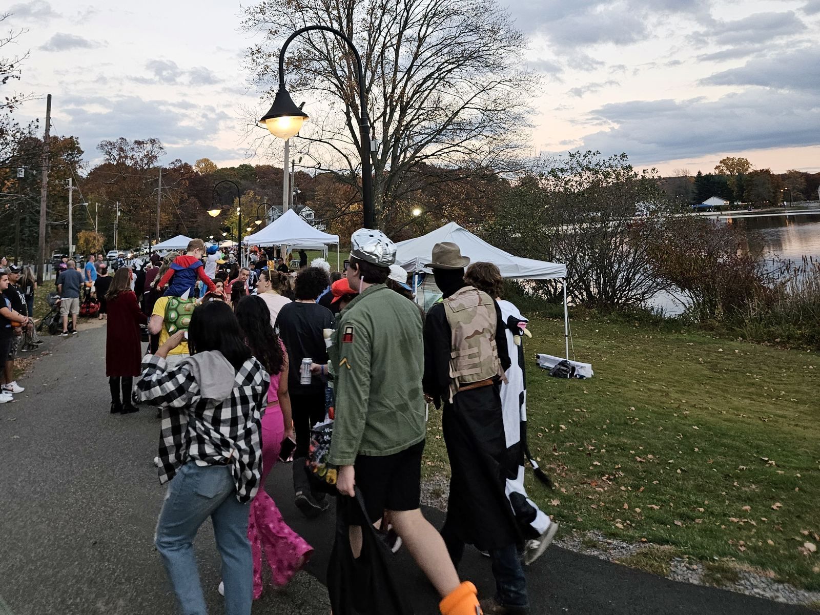 Visitors in Halloween costumes walking the Park Lake path at the Dark Lake Spooktacular in Rockaway, NJ