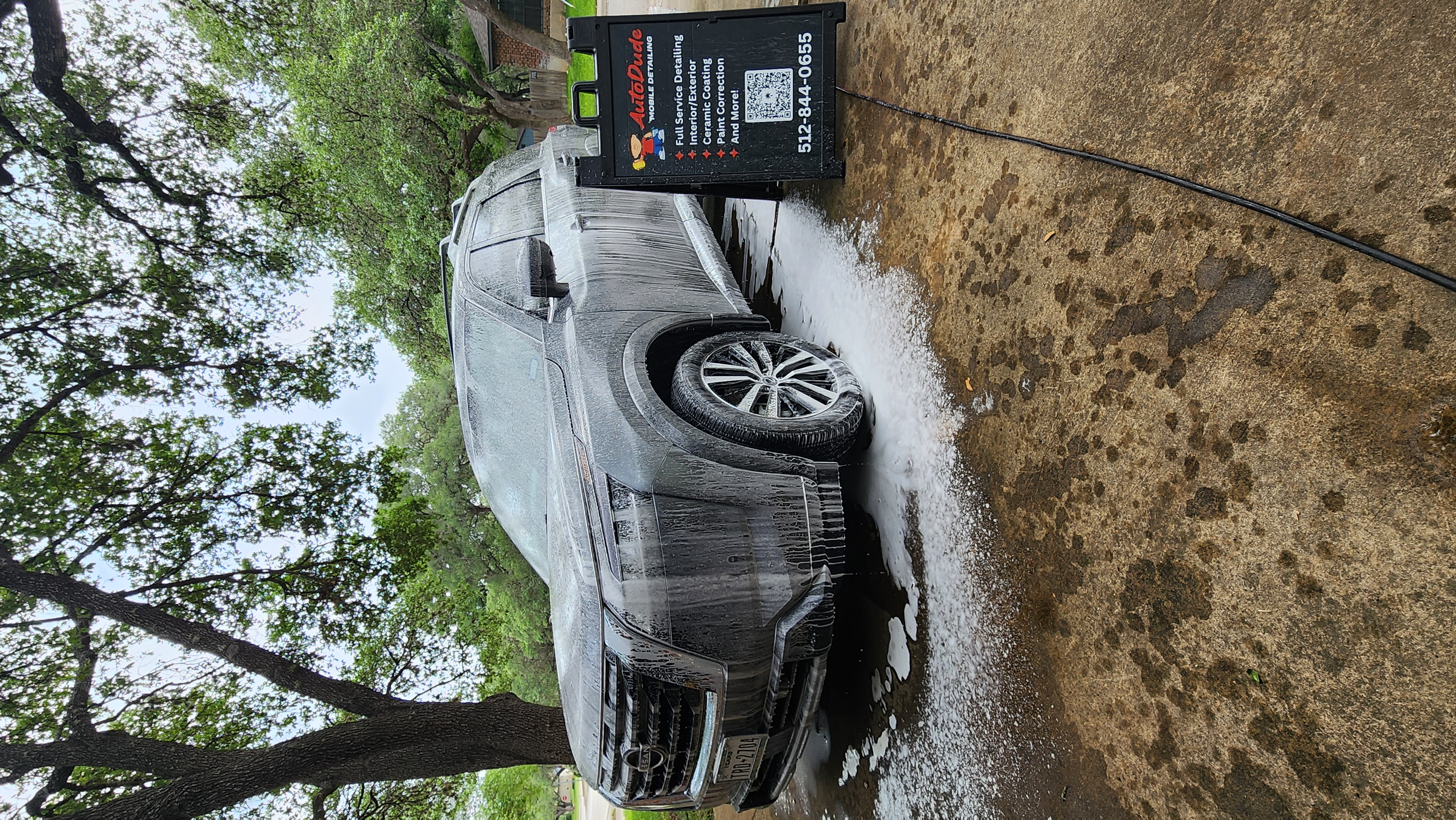Gray Nissan SUV covered in snow foam during an Auto Dude wash
