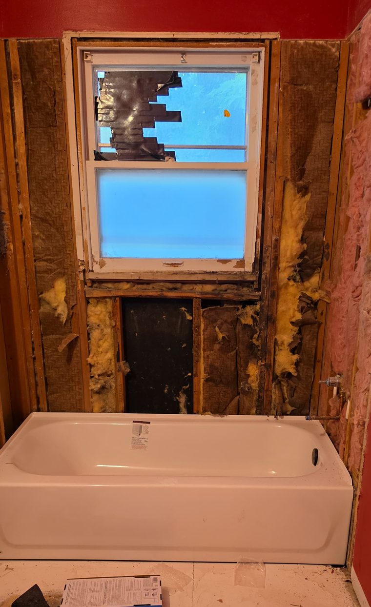 Bathtub set in place during a bathroom wall rebuild.