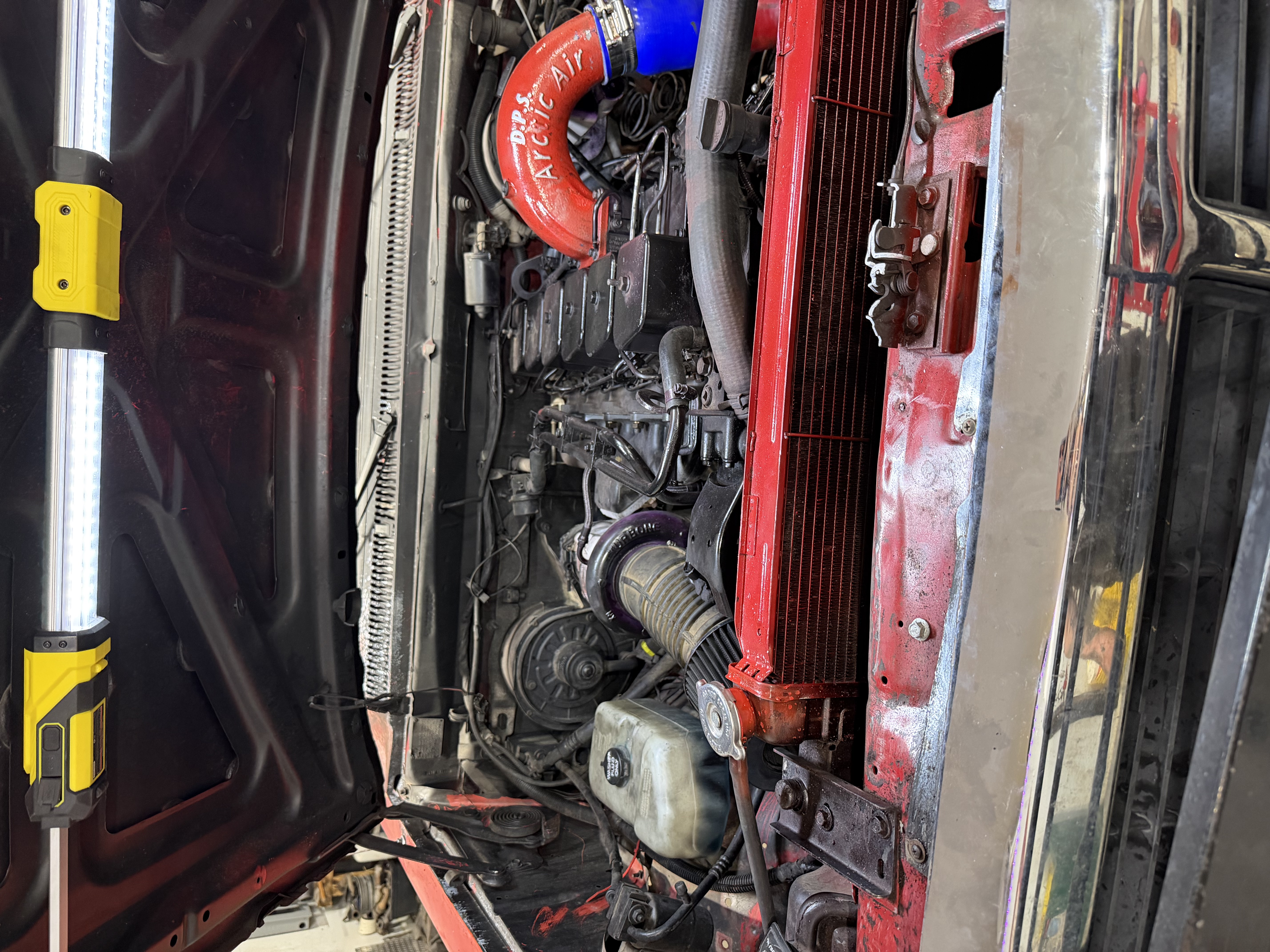 Wiring, piping, and components inside an engine bay.
