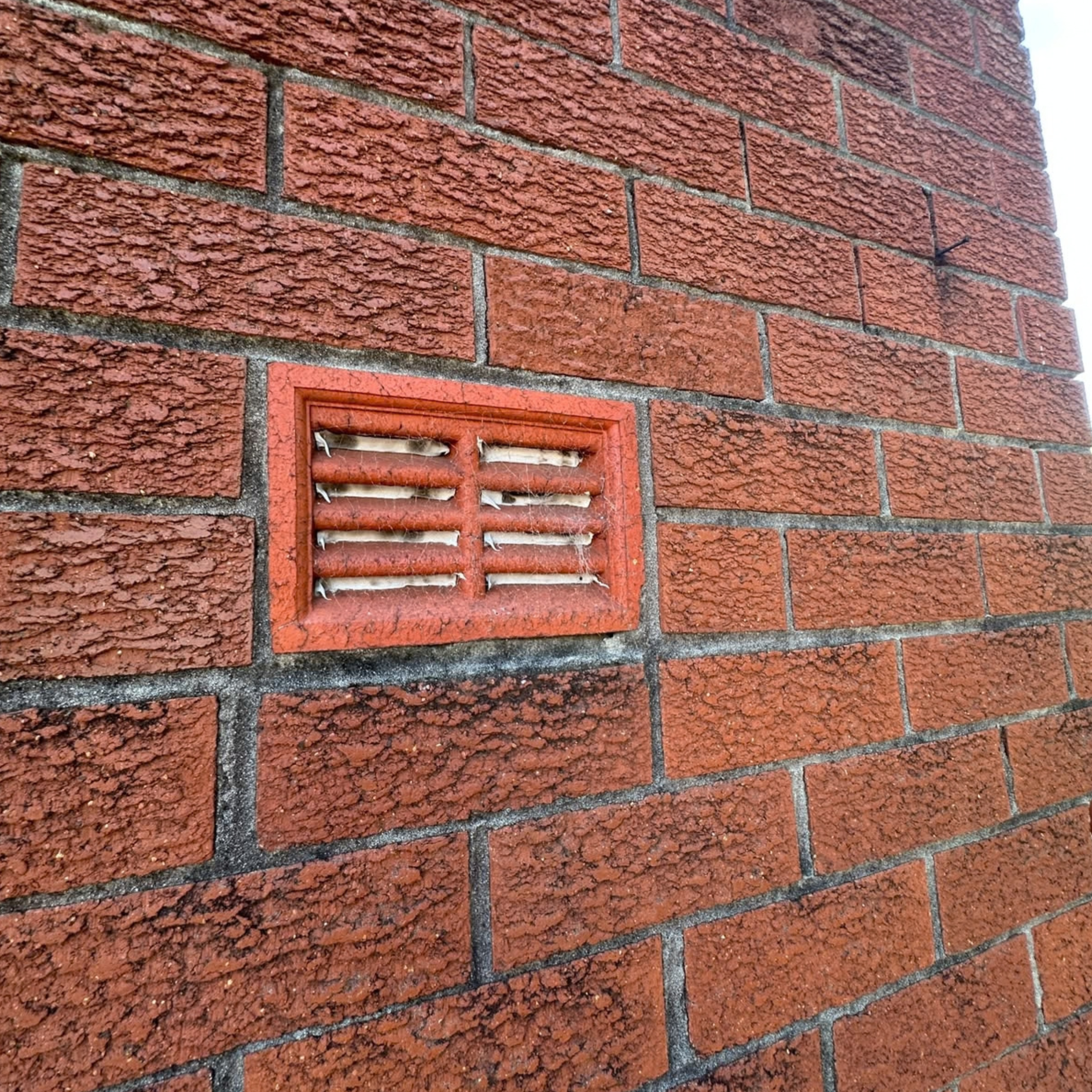 Silicone sealed external vent on a brick unit wall