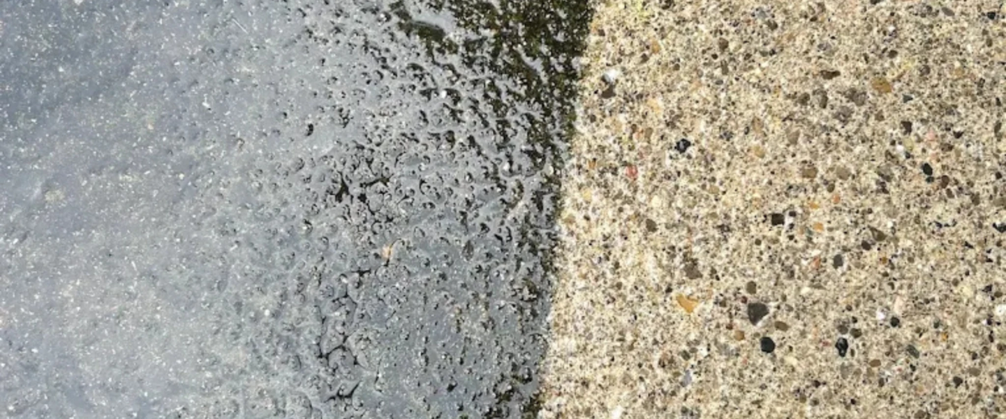 Close-up comparison of dirty vs clean concrete surface after pressure washing.