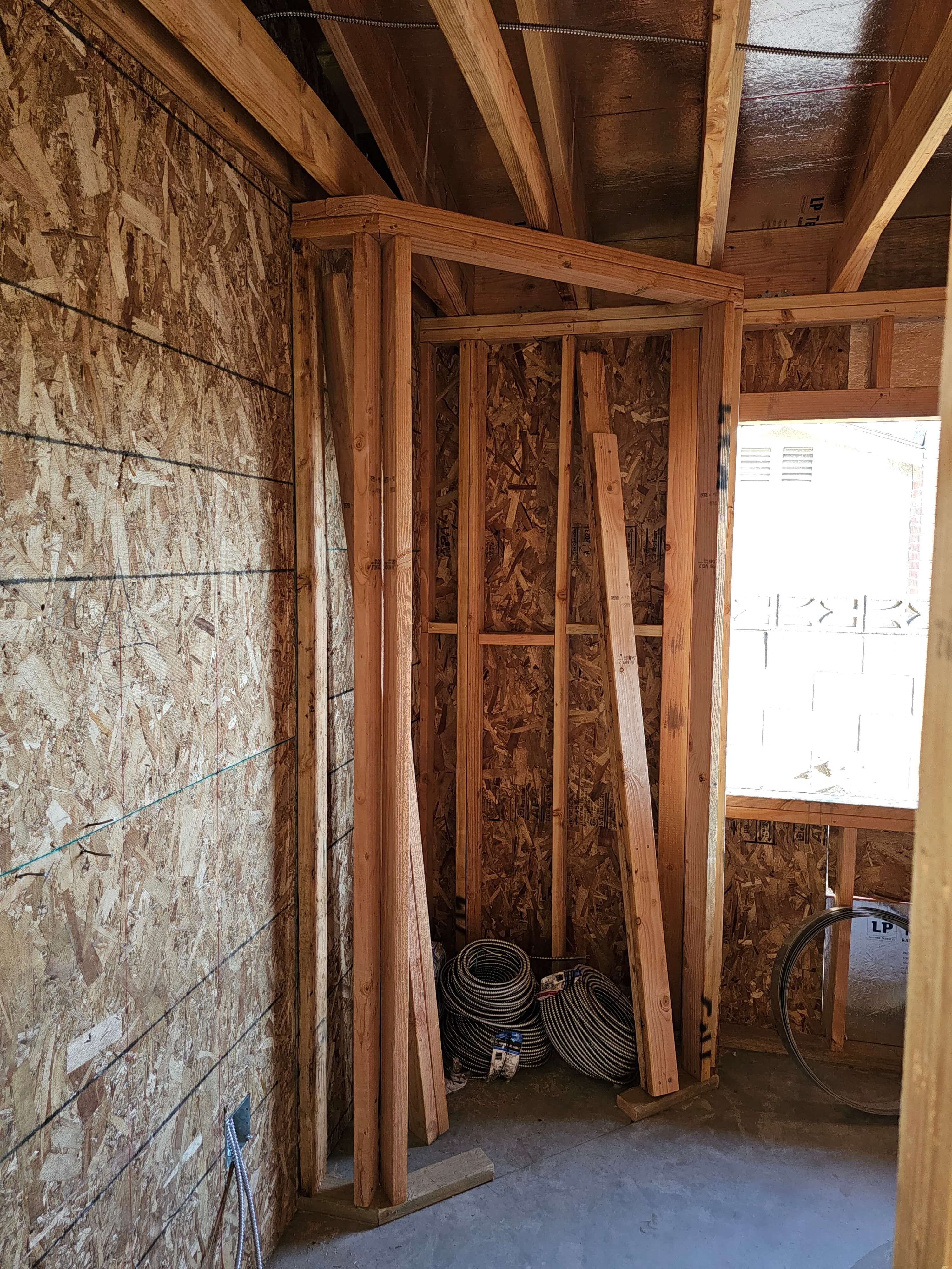 Pomona — framed corner by window, coiled conduit on floor