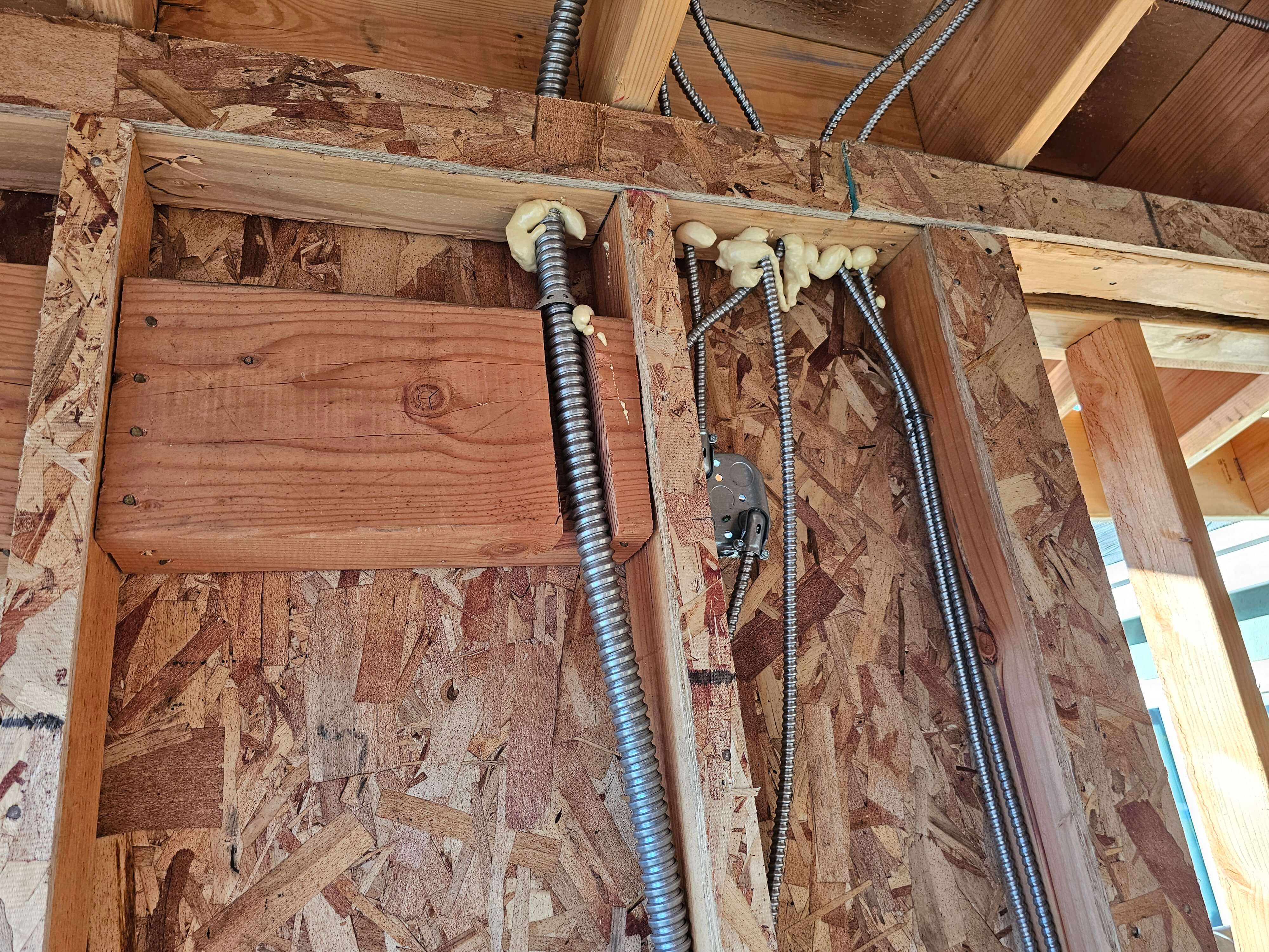 Pomona — MC cables penetrating top plate sealed with spray foam