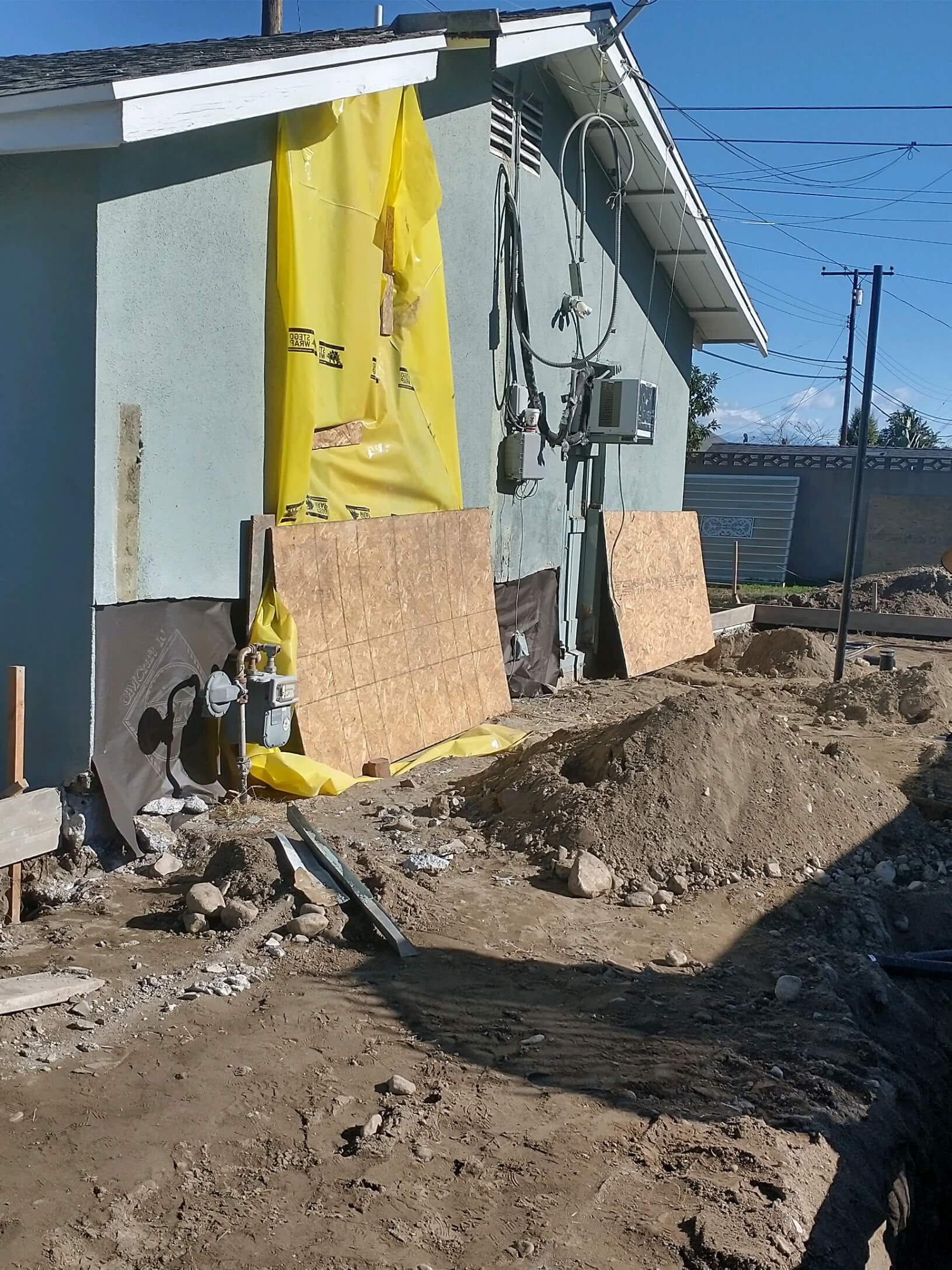 Ontario — site with yellow weather barriers, plywood protection and utility trenching