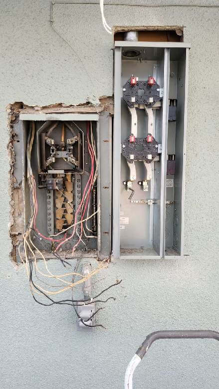 Ontario — old and new electrical meter panels with exposed wiring on stucco