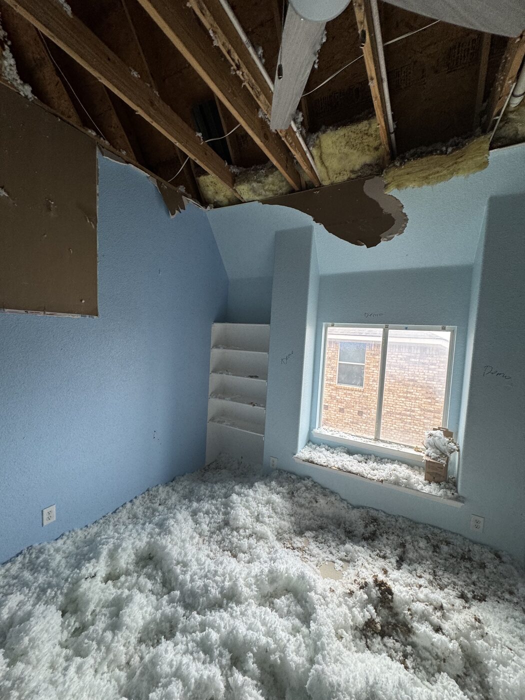 Bedroom with collapsed ceiling drywall and smoke damage before rebuild