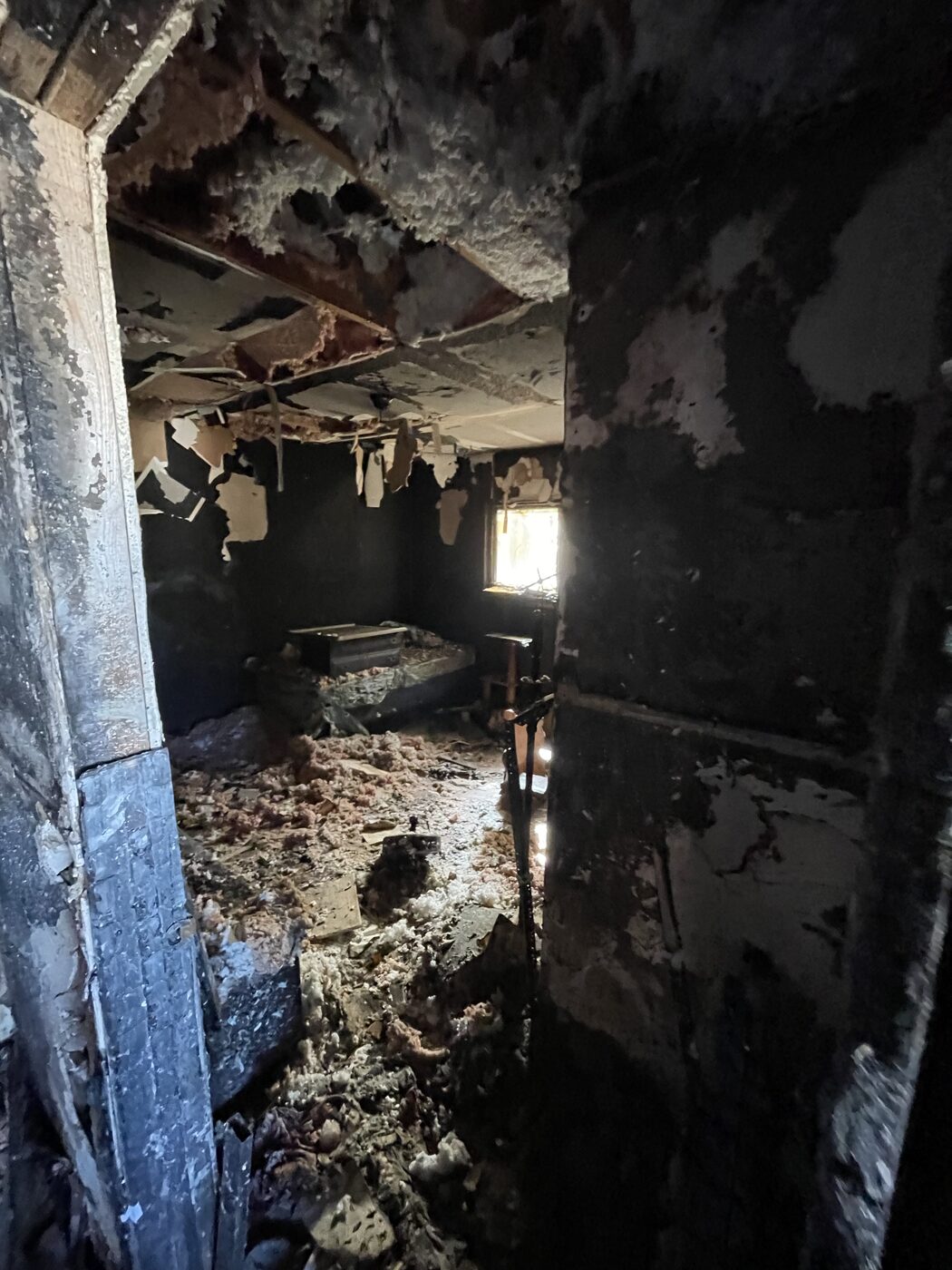 Heavily burned room with soot-covered walls before demolition