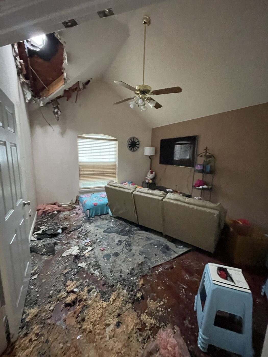 Living room in The Colony, TX with collapsed ceiling and debris after a lightning-strike fire