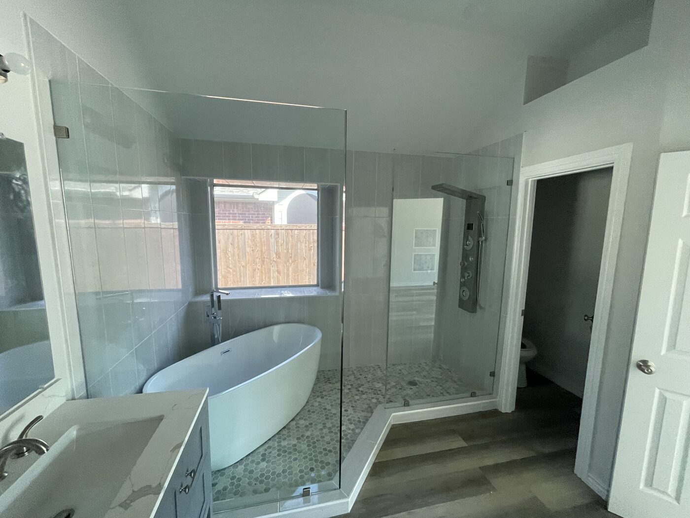 New master bathroom with freestanding tub and glass shower after rebuild