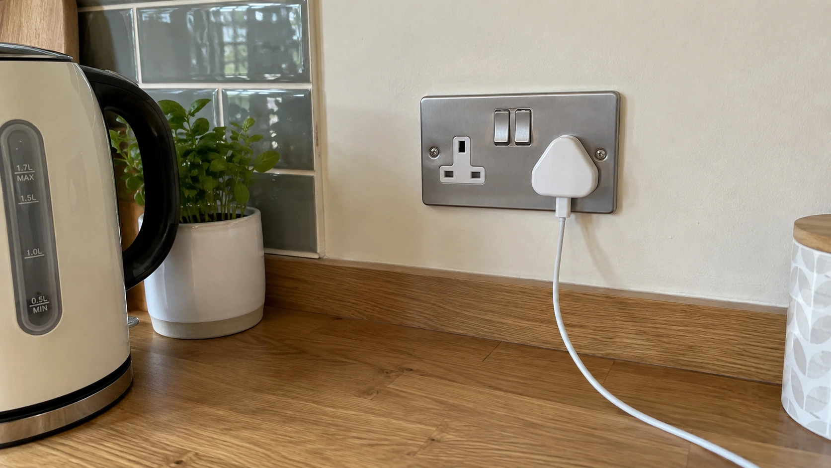 A neatly fitted British double socket above a kitchen worktop.