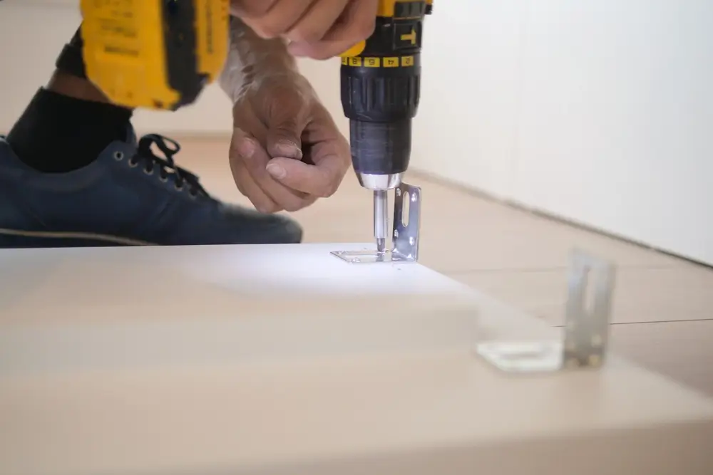 Handyman repairing kitchen cabinet hardware in a Clarence-Rockland home