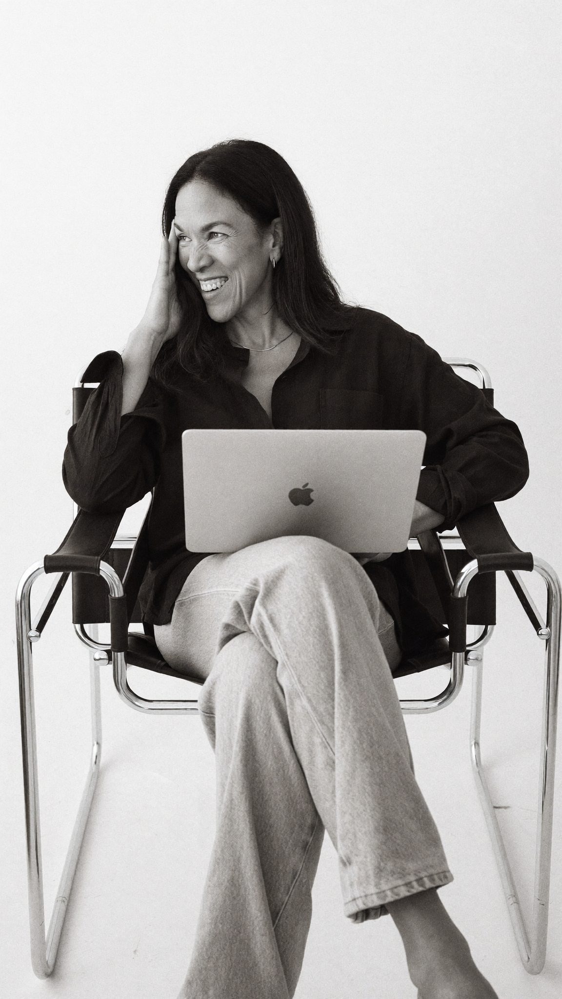Melissa Baker Lanz, laughing with her laptop, black and white portrait