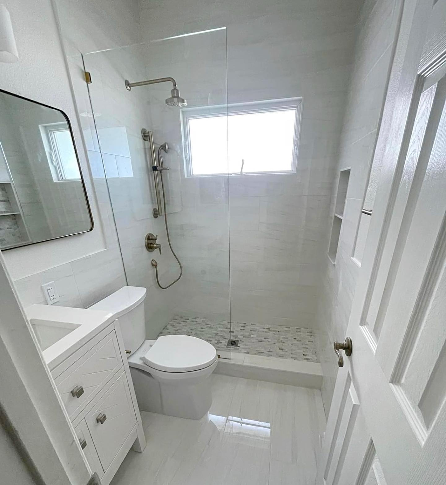 Modern white bathroom remodel by Andler Building Co