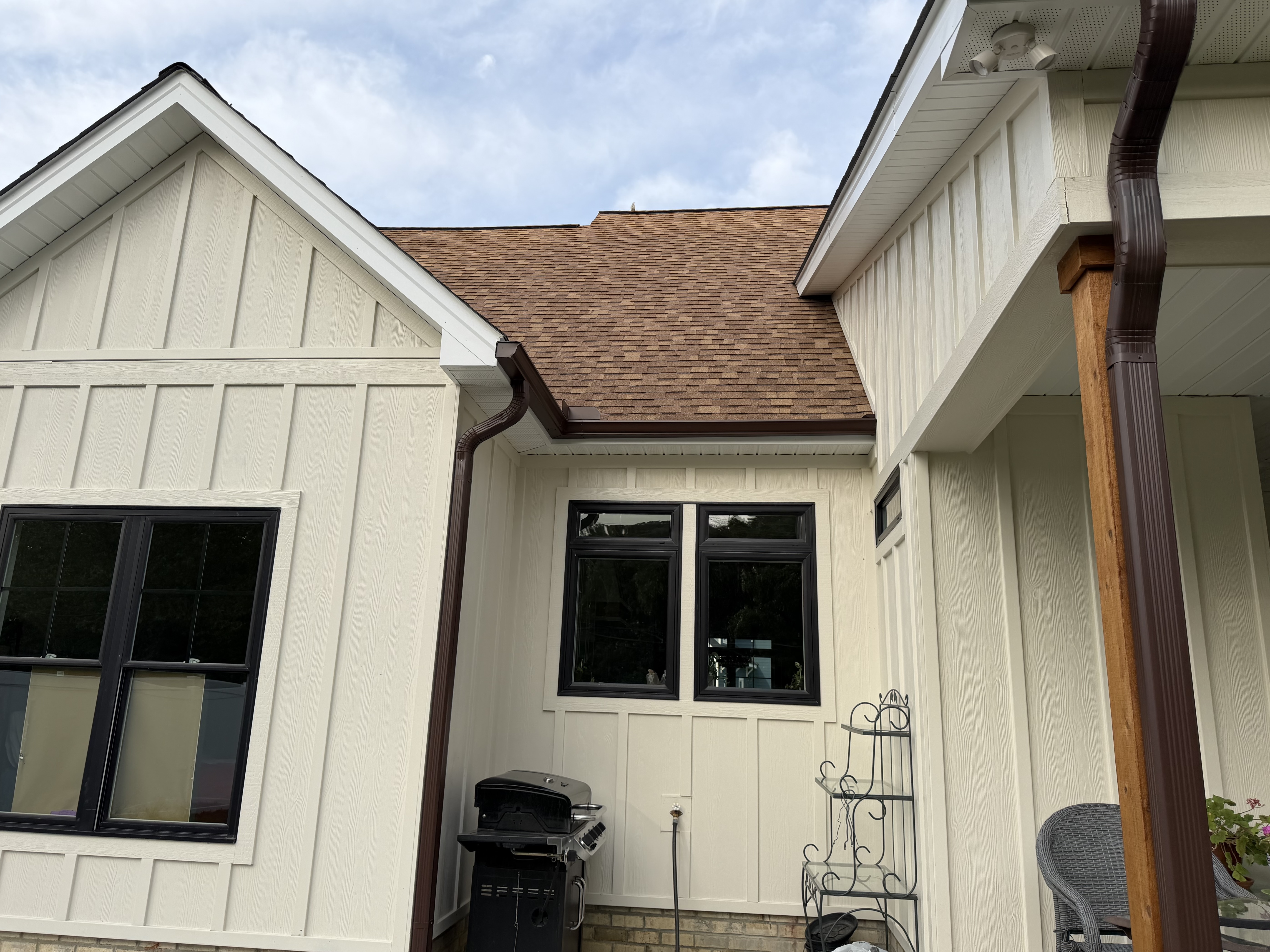 Board-and-batten home with a brown shingle roof