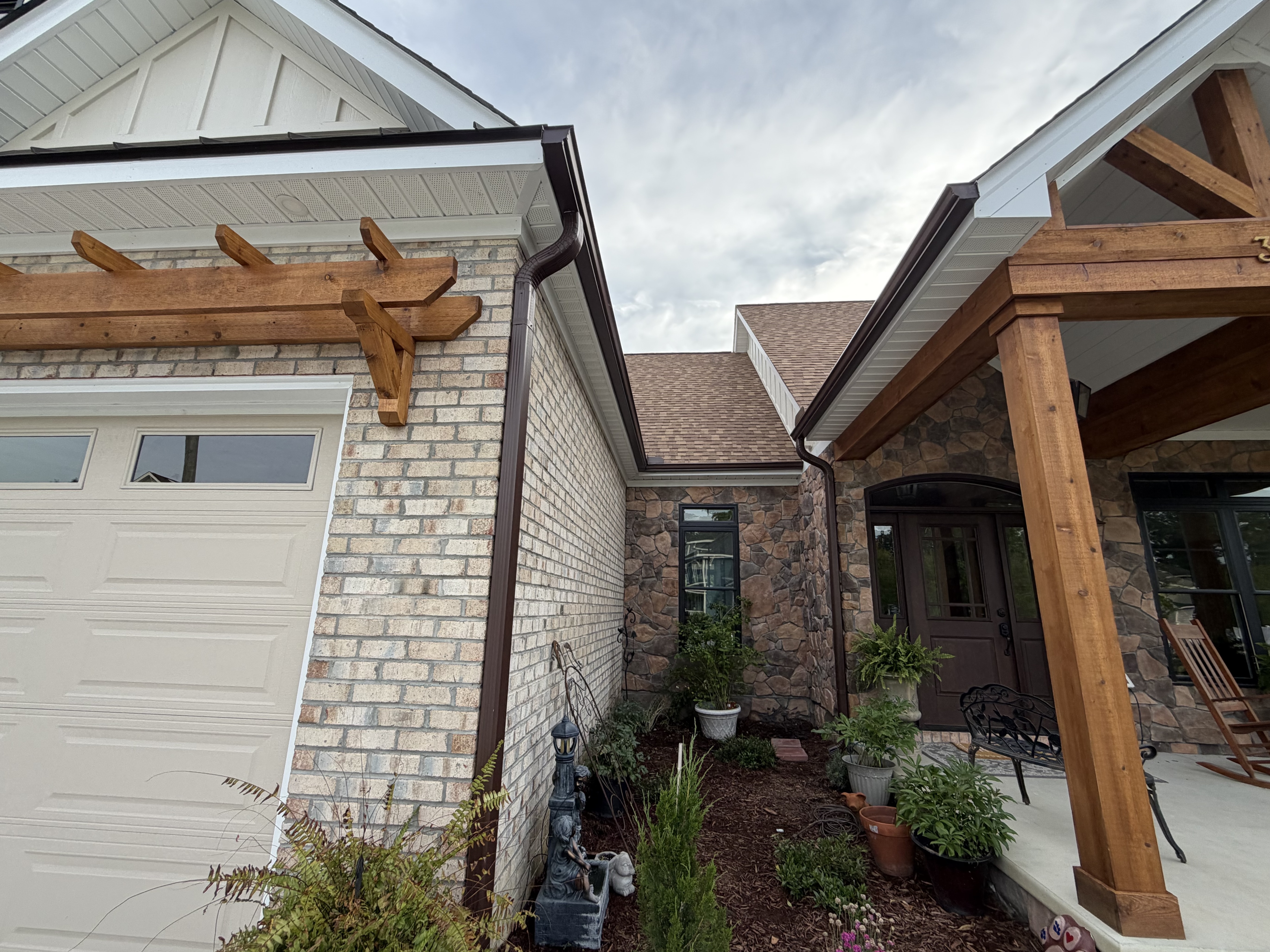 Brick and timber-beam entryway under a brown shingle roof