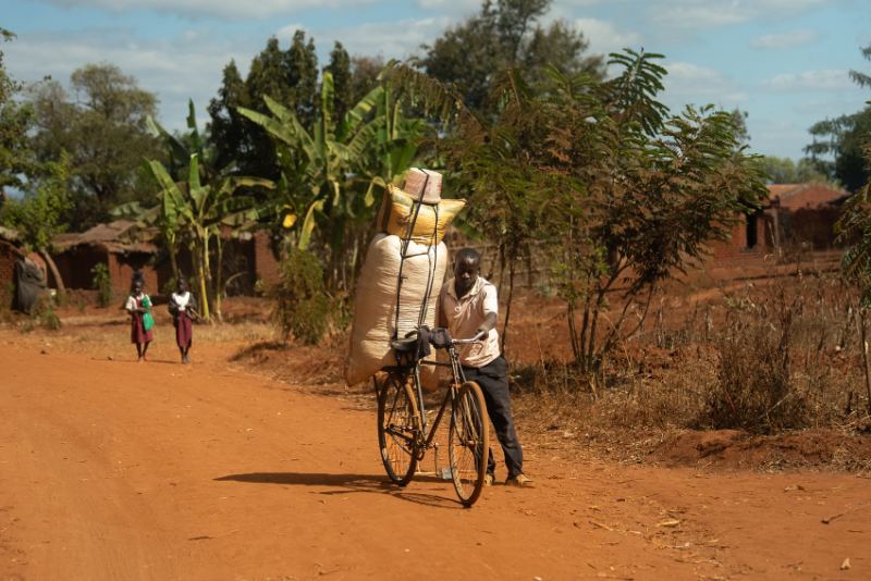 A man riding a bike down a dirt road
