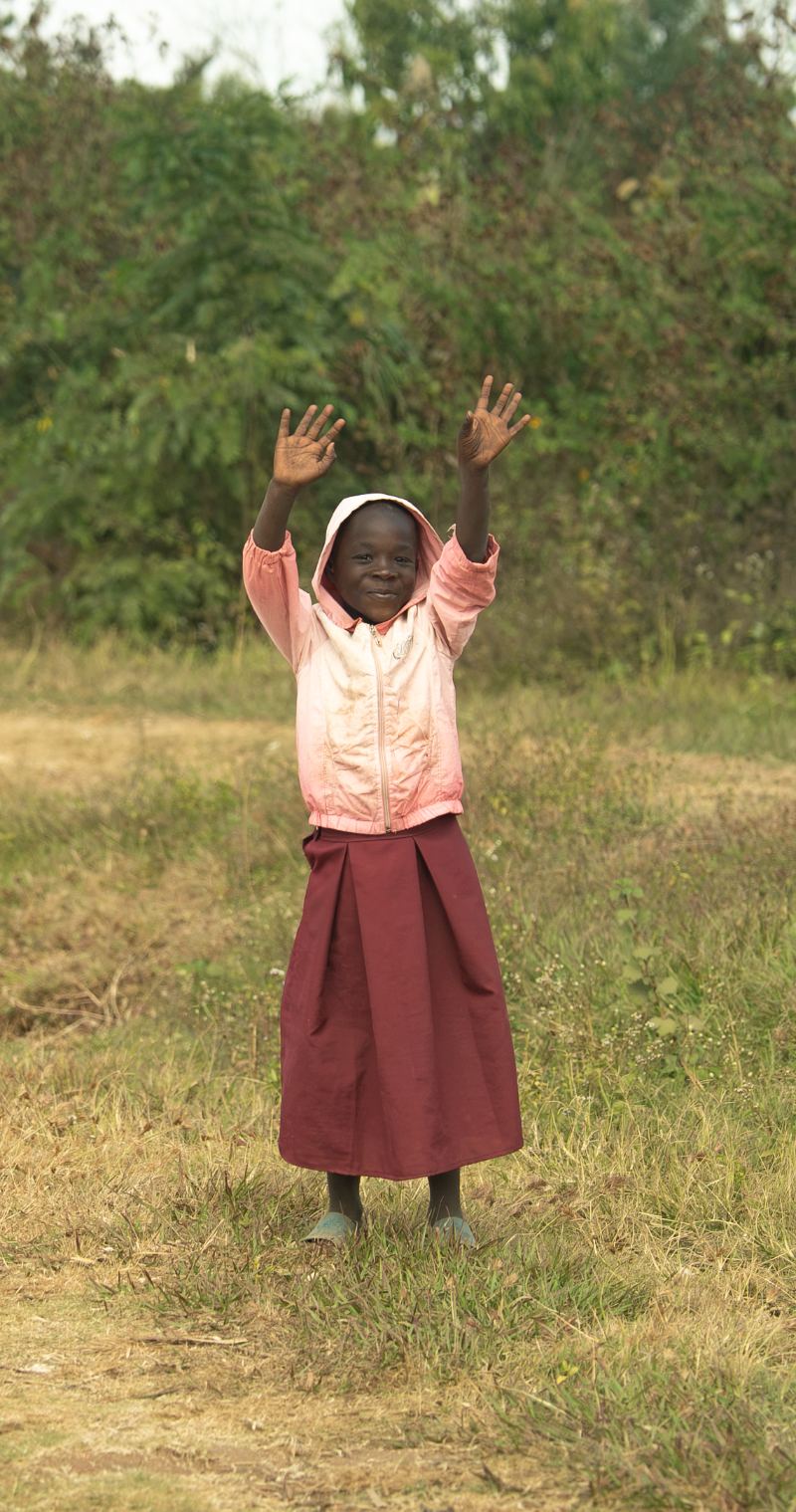 A girl in Malawi with her arms raised