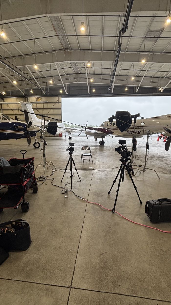 Several camera and lighting setups in an airplane hangar
