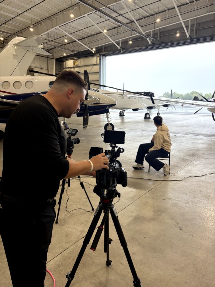 Drew Vernon filming an interview in an airplane hangar