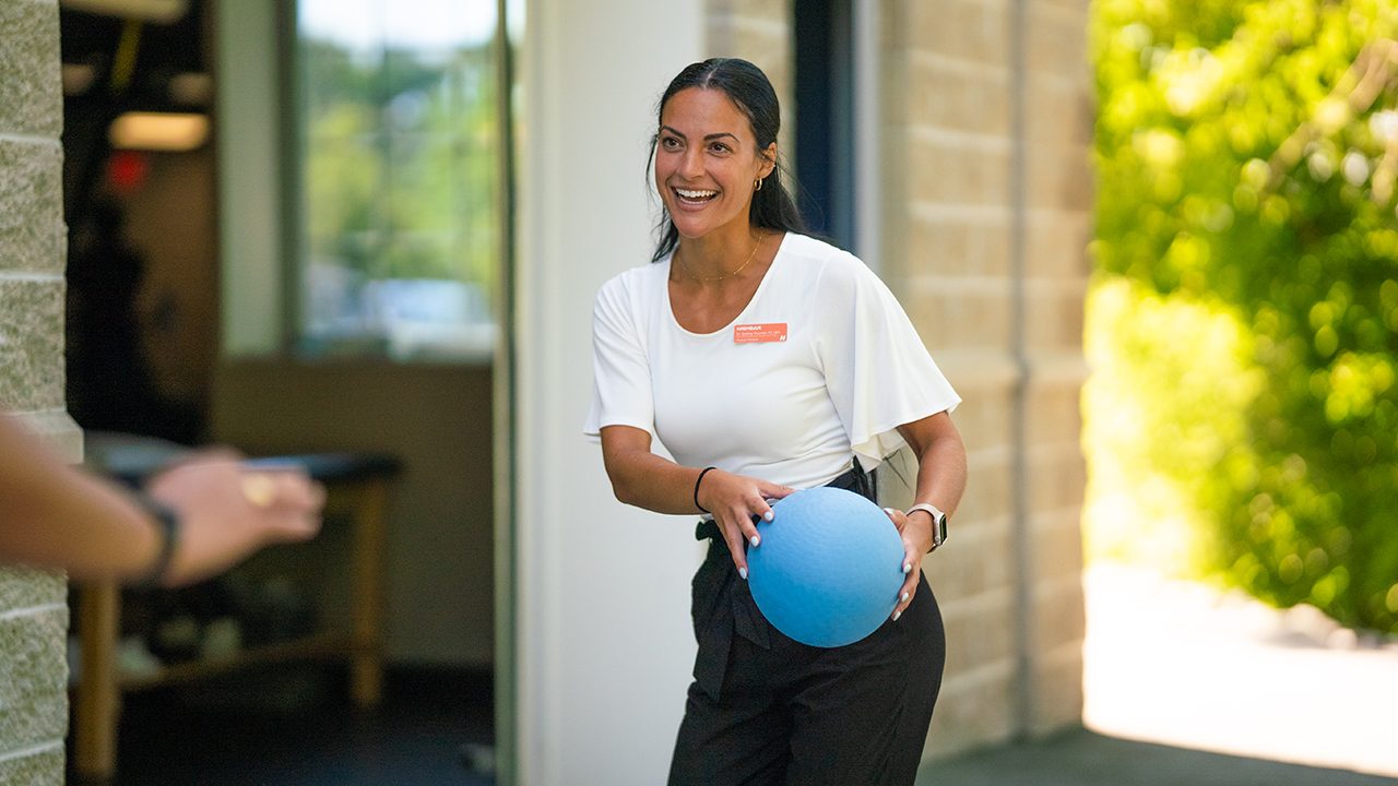 Physical therapist holding a therapy ball in a Cynder Media video