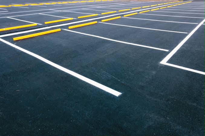 Fresh sealcoat with new white lines and yellow painted parking blocks