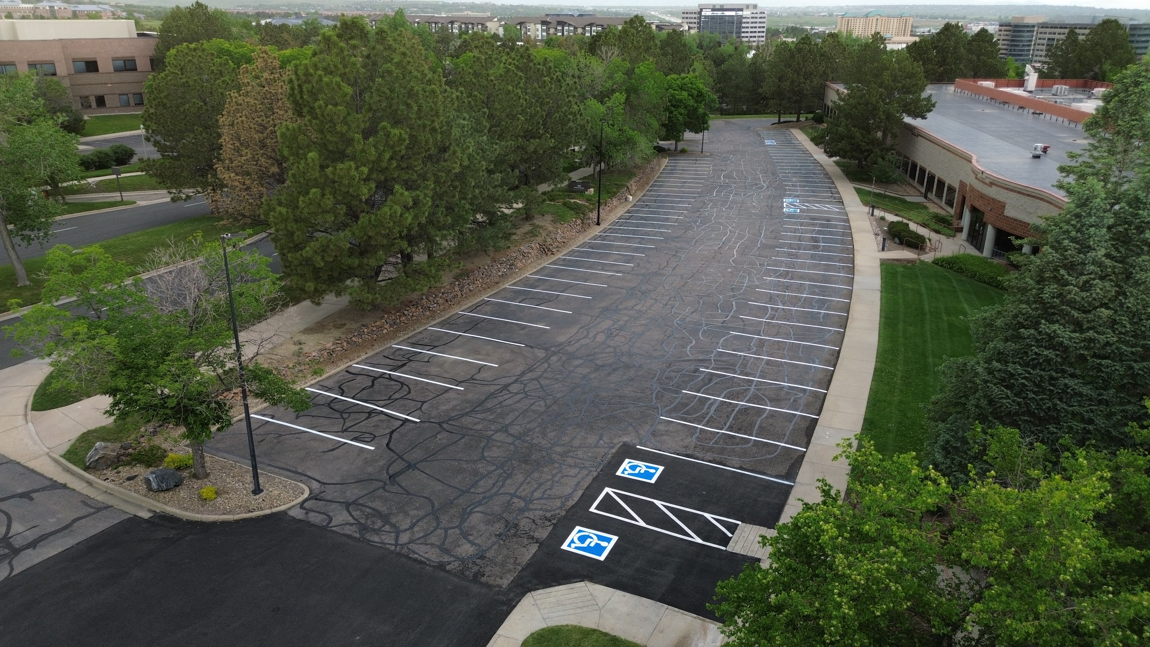 New asphalt patch across two ADA accessible stalls with the lot restriped