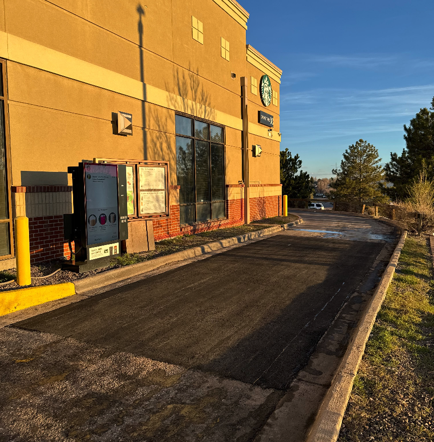 Large remove-and-replace asphalt patch in a coffee shop drive-through lane