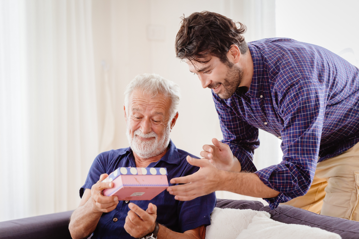 A care team member warmly shaking hands with an older woman at home