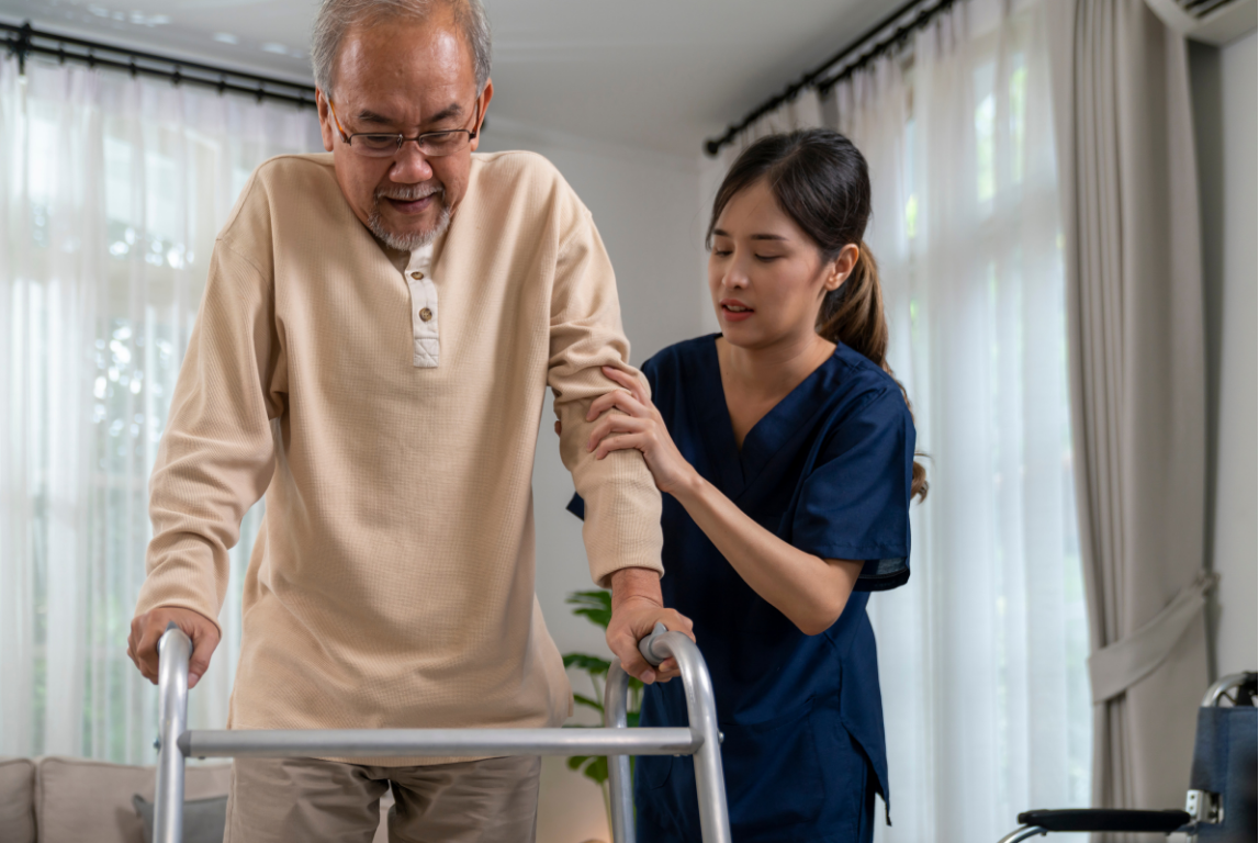 A care team member warmly shaking hands with an older woman at home