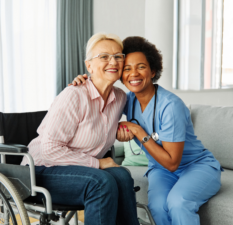 A clinician smiling with her arm around an older woman at home