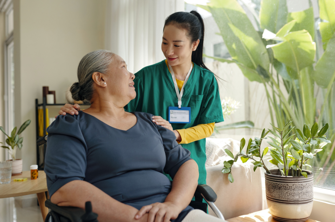 An older woman and her adult daughter sitting together on a sofa at home