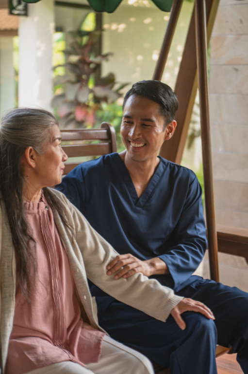 A caregiver holding hands with an older woman at home