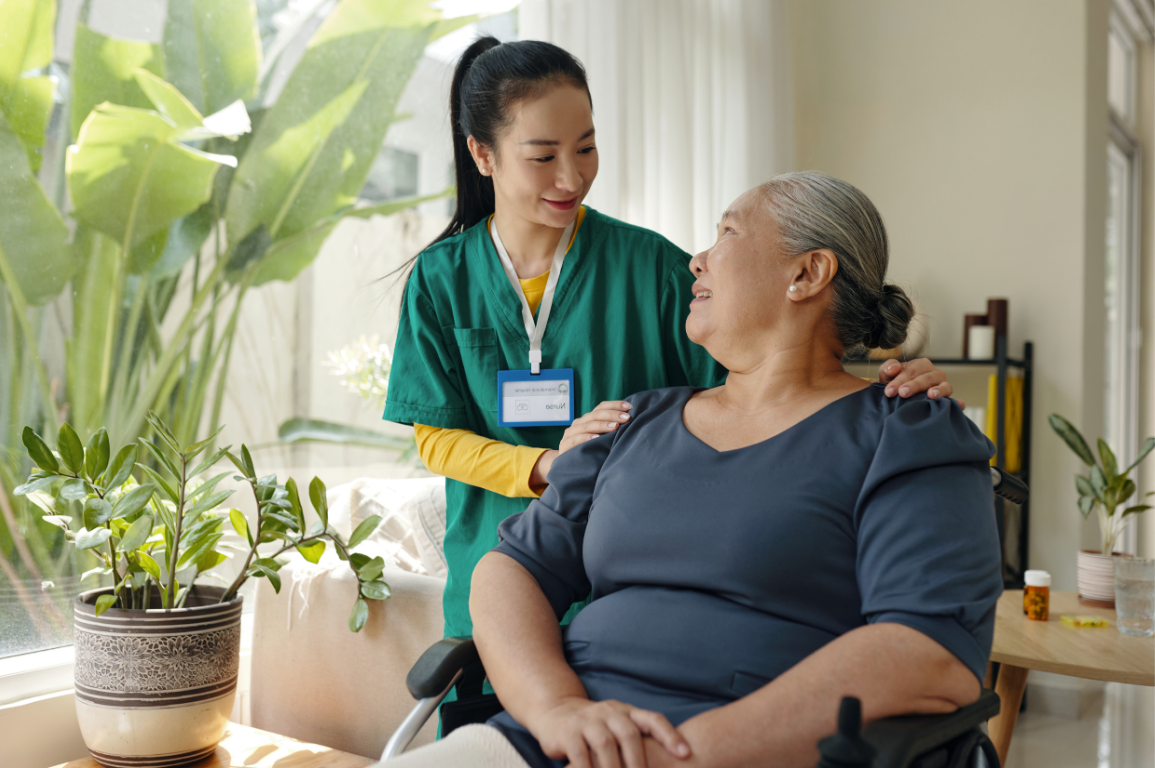 A caregiver helping an older man with an exercise at home