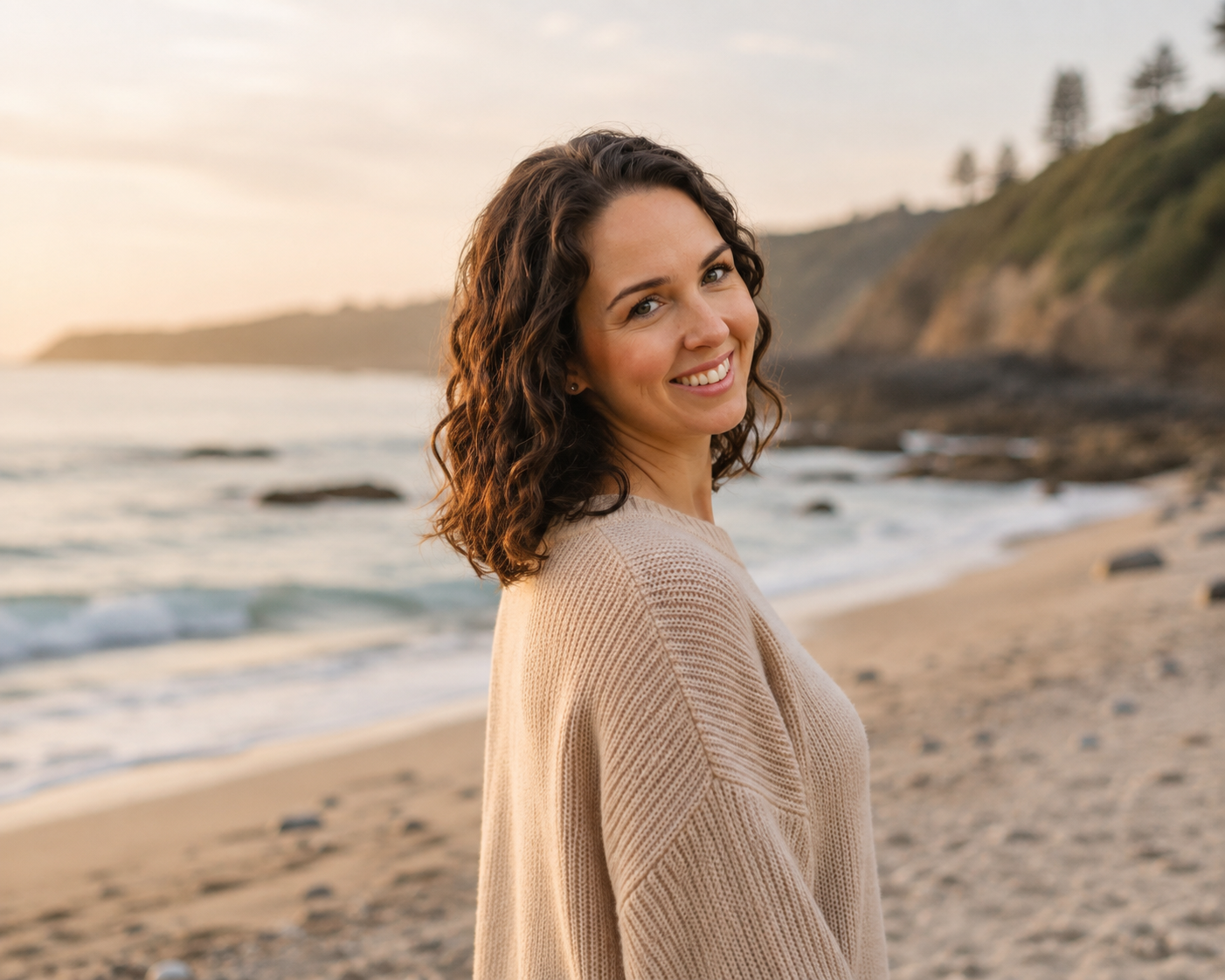 Alicia smiling on the beach at golden hour