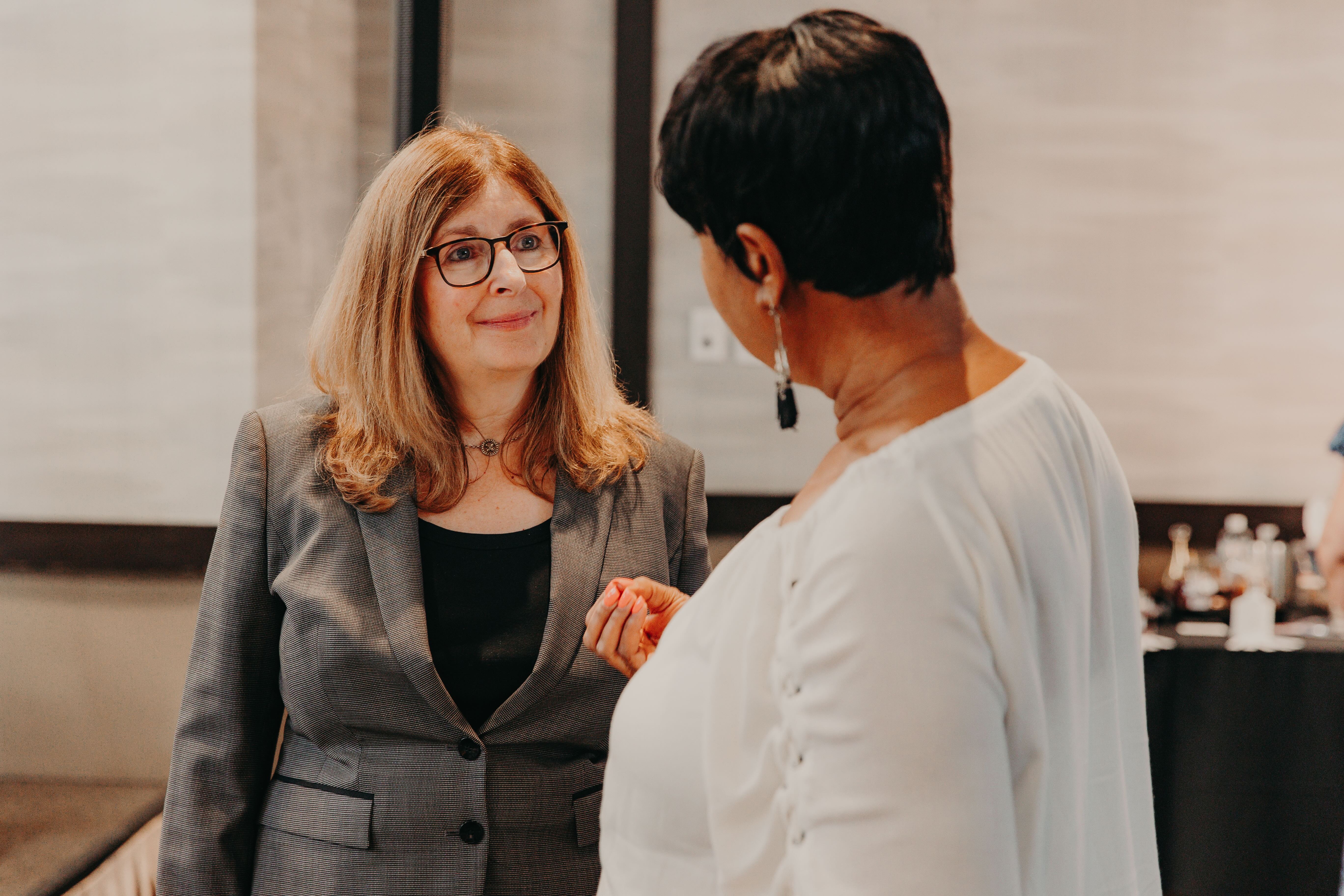 Tracy listening to a woman at an event