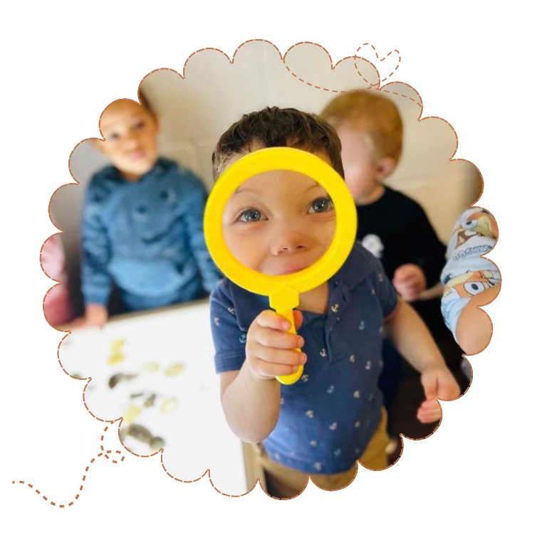 child looking into yellow magnifying glass 