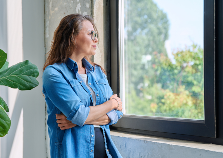 A woman staring out the window wondering why do I keep things I don’t need anymore